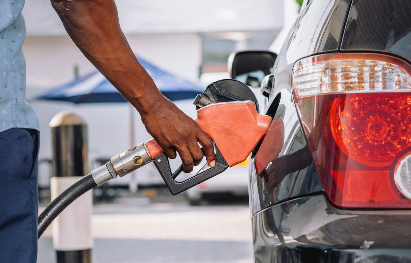 A forecourt attendant refuelling a car